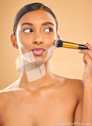 Image of Indian woman, beauty and brush for makeup with cosmetic tools, skin glow and kiss face on studio background. Happy female, thinking and cosmetology, apply foundation or powder with self care