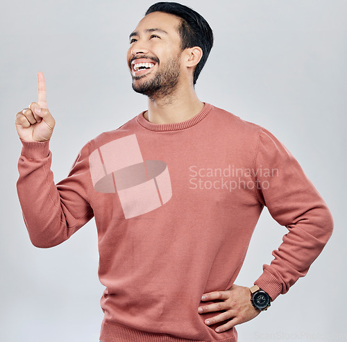 Image of Happy, smile and pointing with man in studio for idea, product placement and announcement. Success, confident and direction with male isolated on white background for positive, advertisement or pride