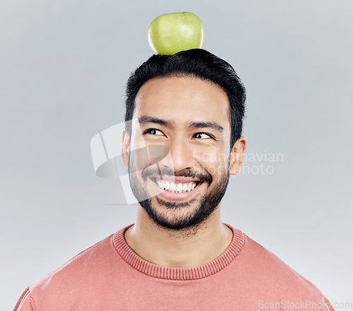 Image of Happy, healthy and an Asian man thinking of an apple isolated on a white background in a studio. Smile, idea and a Chinese guy with a fruit for nutrition, diet and organic wellness on a backdrop