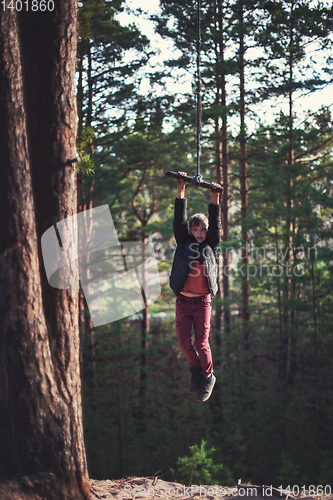 Image of Teen boy at bungee in autumn forest