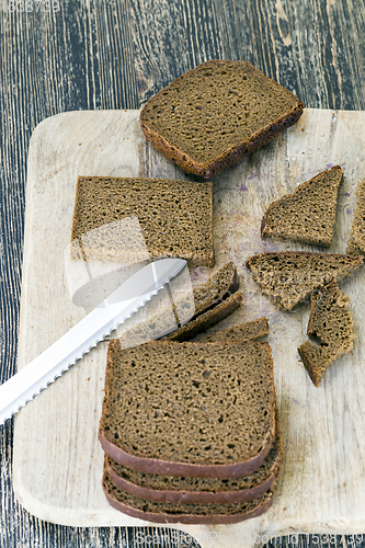 Image of bread sliced on wooden cutting Board