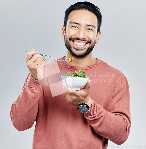Image of Man, salad and eating healthy portrait in studio for wellness food motivation with vegetables. Asian male smile for vegetable nutrition, diet and benefit for digestion or lose weight white background