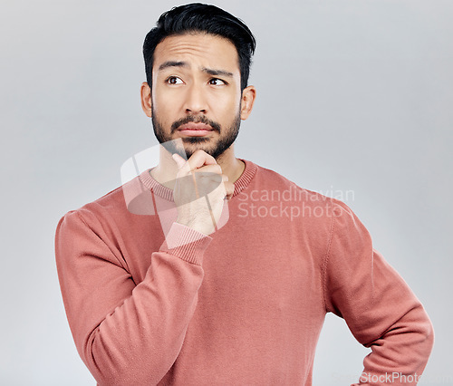 Image of Confused, thinking and Asian man with ideas, decision and thoughtful against grey studio background. Japan, male and guy with wonder, opportunity and confused with thoughts, contemplation and future