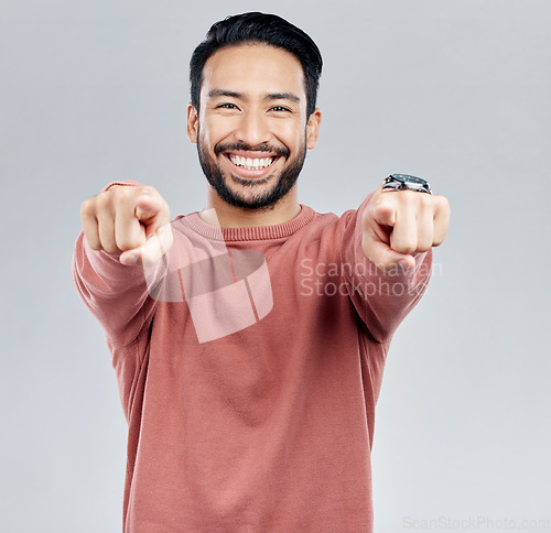 Image of Pointing, selection and smile with portrait of man in studio for thank you, motivation and amazing. Winner, confident and friendly with male on white background for yes, achievement and satisfaction