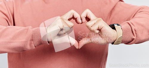 Image of Man, heart and hands for love in studio to show support, thank you or charity sign language. Male model person with hand icon for kindness, care and hope review, motivation or emoji opinion feedback