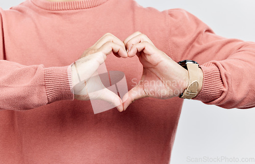 Image of Heart, man and hands for love in studio to show support, thank you or charity sign language. Male model person with hand icon for kindness, care and hope review, motivation or emoji opinion feedback