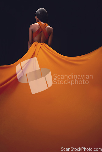 Image of Dress, train and woman back, elegant style and beauty on dark background, fashion and model in orange in studio. Classy female, glamour and stylish ballgown with sexy person, luxury and designer wear