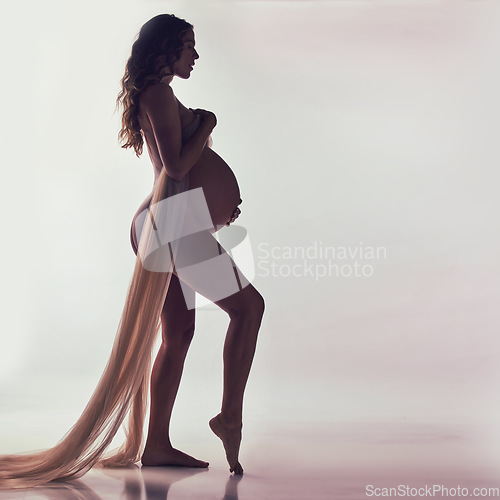 Image of Woman, pregnant and fabric with silhouette in studio with hands, touch and healthy by white background. Pregnancy model, shadow art or wellness mockup with cloth, body and stomach with dark aesthetic