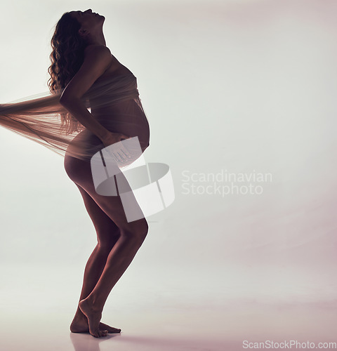 Image of Woman, pregnancy and fabric on stomach in studio with hands, touch and art by white background. Pregnant model, shadow and wellness mockup with cloth for body, belly or silhouette with dark aesthetic