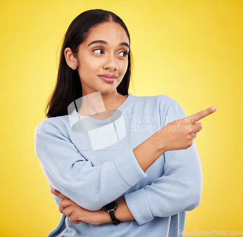 Image of Yellow background, point and face of woman in studio for advertising, promotion and announcement. Mockup space, news and isolated girl with hand gesture showing information, discount and branding