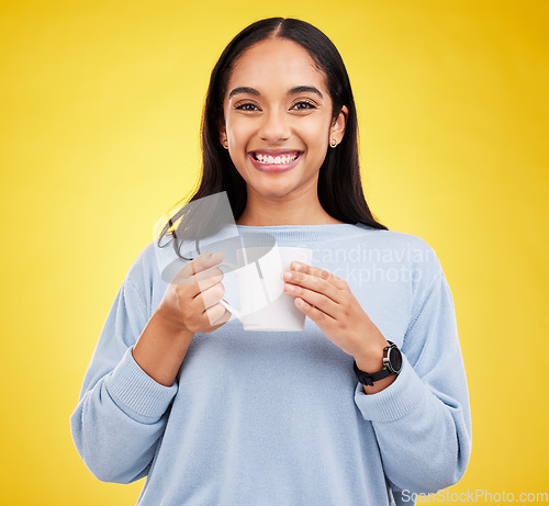 Image of Smiling portrait, coffee mug and happy woman in a studio with a smile from espresso. Isolated, yellow background and drink of a young female with happiness and joy ready to start the day with tea