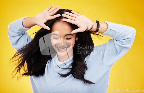 Image of Happy, freedom and calm with a woman on a yellow background in studio feeling carefree or cheerful. Smile, relax and relief with an attractive young female posing eyes closed in a peaceful mood