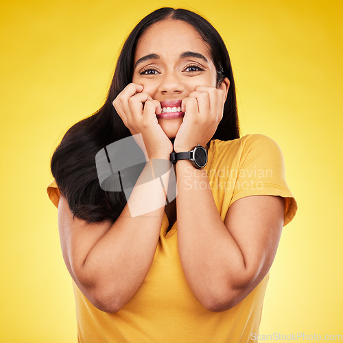 Image of Nervous, fear portrait and woman in a studio with stress and anxiety with nail biting. Isolated, yellow background and panic of a scared person feeling terror, phobia and mental health problem