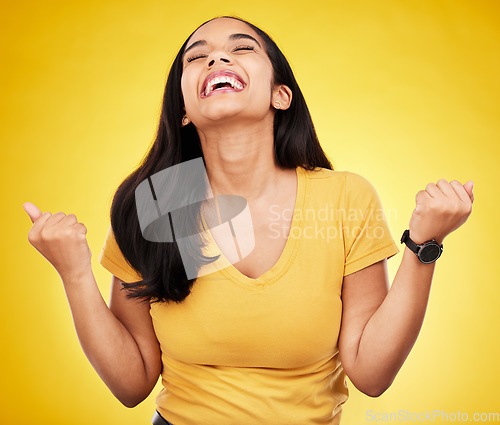 Image of Woman, happy and fist of winner in studio for celebration, achievement deal and lotto success. Excited female model celebrate winning prize on yellow background for lottery, bonus victory and smile