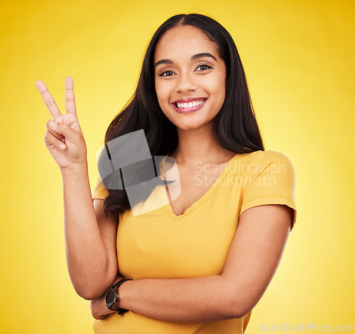 Image of Portrait of woman, smile and peace fingers in studio, yellow background and color backdrop. Happy female model, v sign and hands of victory, fun mood and happiness of gen z, victory and freedom emoji