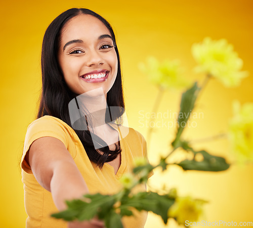 Image of Happy, summer and portrait of woman with flowers or plants feeling excited and isolated in a studio yellow background. Smile, happiness and young female holding a gift with a floral blossom aesthetic