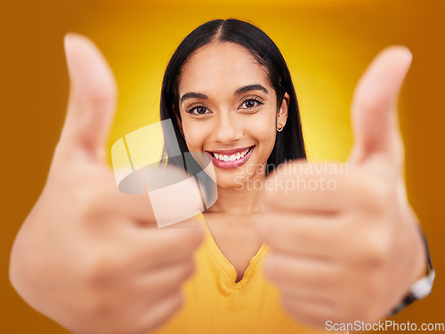 Image of Thumbs up, portrait and hands of happy woman in studio, excited winner and bonus on background. Female model, thumb and smile to celebrate winning achievement, like emoji and support, yes or feedback