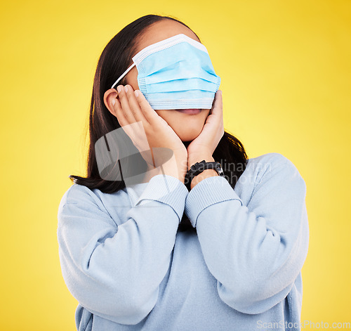 Image of Covid, face mask and shock with woman and blindfold in studio for medical, crazy and healthcare. Comic, virus and carefree with female on yellow background for vaccine, protection and pandemic