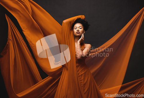 Image of Black woman, art and fashion, flowing fabric on dark background with beauty and aesthetic movement. Silk, fantasy and artistic portrait of serious African model in creative designer dress in studio.