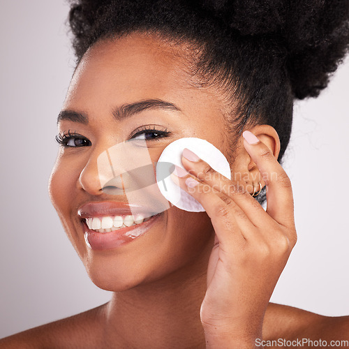 Image of Black woman, cotton and skincare in studio with smile in headshot, cleaning or makeup removal by background. Young model, wipe and clean for natural glow, wellness and cosmetic beauty for self care