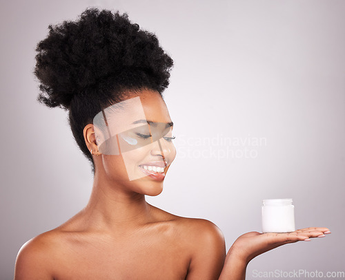 Image of Black woman, moisturizer cream and smile for skincare beauty or cosmetics against a gray studio background. Happy African female smiling and holding moisturizing creme, lotion or facial product