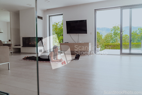 Image of Young Beautiful Female Woman with Trainer via Video Call Conference in Bright Sunny House. Healthy Lifestyle, Wellbeing and Mindfulness Concept.