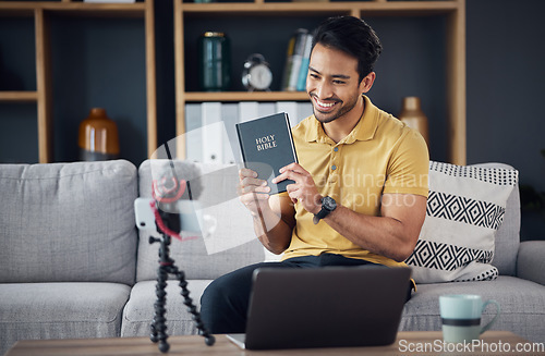 Image of Bible, smile and man study with phone and microphone online live streaming. Asian male on home sofa with Christian religion book as blog or podcast content creator or influencer teaching or studying