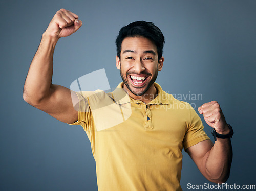 Image of Indian man, celebrate and fist in studio portrait for winning mindset, happiness or achievement by background. Young model, male student or celebration with happy, excited face or winning for success