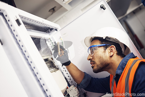 Image of Electrician, engineer and maintenance man with screwdriver in control room for power box. Male technician person for inspection service for engineering, electricity or energy supply repair with torch