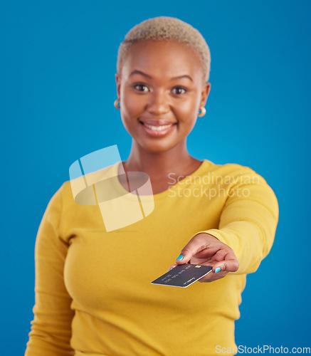 Image of Credit card, payment and woman portrait in a studio with a smile from paying with happiness. Isolated, blue background and ecommerce with a young female model hand showing financial banking method