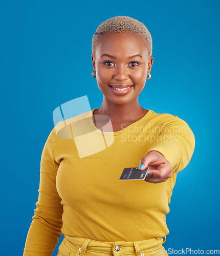 Image of Credit card, payment portrait and happy woman in a studio with success from paying a bill. Isolated, blue background and ecommerce with a young female model hand showing financial banking method