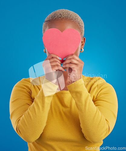 Image of Paper, heart and hide with black woman in studio for love, date and kindness. Invitation, romance and feelings with female and shape isolated on blue background for emotion, support and affectionate