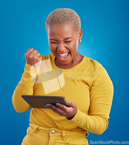 Image of Success winner woman on tablet isolated on blue background fist pump, yes and cheers for online news. Winning, competition and giveaway prize for african person on digital tech celebration in studio