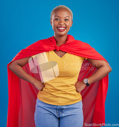 Image of Black woman, superhero cape and portrait in studio, blue background and fashion. Happy female model, superwoman and brave cosplay character of justice, smile and pride of girl power, proud and strong