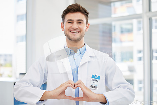 Image of Healthcare, hands in heart and portrait of doctor in hospital with emoji for wellness, medicine and medical care. Smile, love gesture and happy man in clinic for consulting, insurance and support