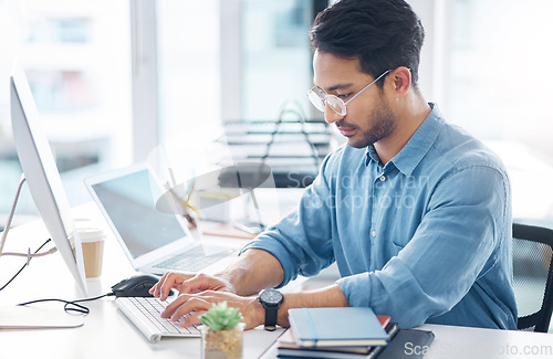 Image of Serious, business man and typing on computer in office for startup management, planning and agency. Focused male worker at desktop technology for online project, website or internet research at table