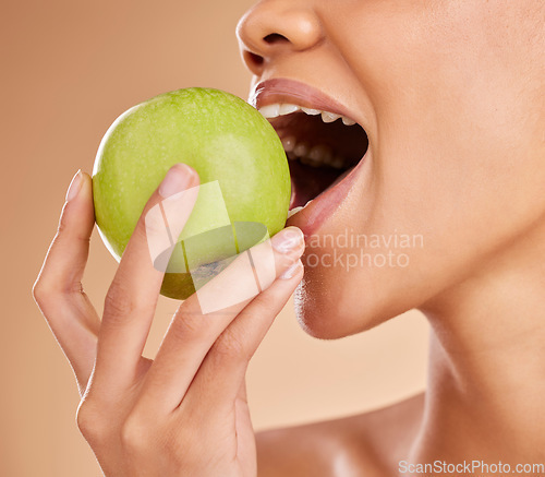 Image of Apple, dental or mouth of woman eating in studio on beige background for healthy nutrition or clean diet. Bite, hand or zoom of hungry girl advertising or marketing natural green fruits for wellness