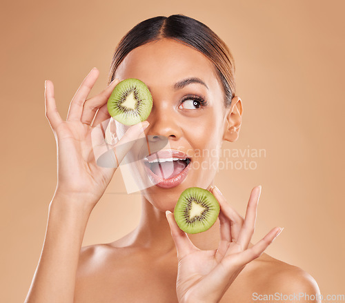 Image of Kiwi, skincare and face of woman in studio for organic wellness, facial treatment and natural cosmetics. Beauty, spa aesthetic and happy girl smile with fruit for detox, dermatology and healthy skin