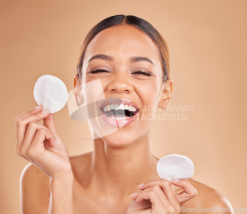 Image of Face, funny and woman with cotton pad, skincare and happiness against a brown studio background. Portrait female and lady laughing, makeup remover and foundation with smile, dermatology and grooming