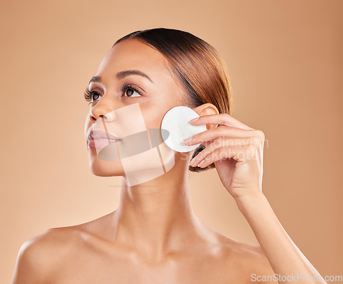 Image of Beauty, cotton and cleaning face of woman in studio with dermatology, cosmetic and detox. Aesthetic model with hands for natural facial makeup clean, self care and skincare for glow or wellness