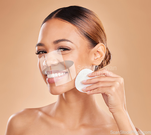 Image of Cleaning face, cotton and beauty of woman portrait in studio with dermatology, cosmetic and detox. Aesthetic female with hand for natural facial makeup clean, self care and skincare brown background