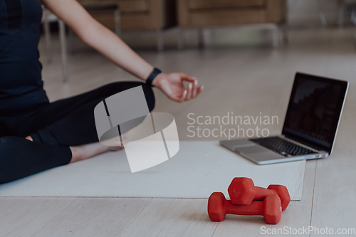 Image of Young Beautiful Female Exercising, Stretching and Practising Yoga with Trainer via Video Call Conference in Bright Sunny House. Healthy Lifestyle, Wellbeing and Mindfulness Concept.