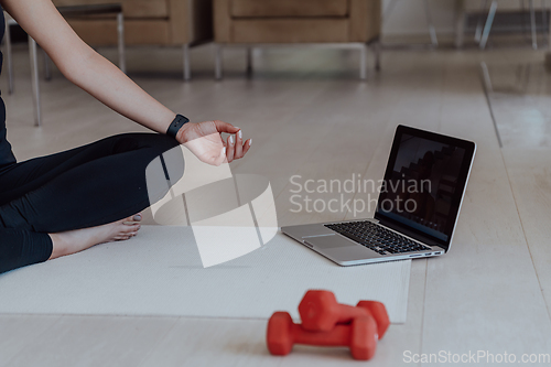 Image of Young Beautiful Female Exercising, Stretching and Practising Yoga with Trainer via Video Call Conference in Bright Sunny House. Healthy Lifestyle, Wellbeing and Mindfulness Concept.