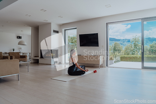 Image of Young Beautiful Female Exercising, Stretching and Practising Yoga with Trainer via Video Call Conference in Bright Sunny House. Healthy Lifestyle, Wellbeing and Mindfulness Concept.