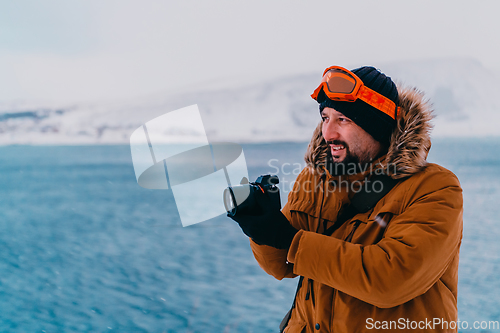 Image of A photographer in the cold Skavdinava regions tries to take a photo for journalism in a strong winter storm