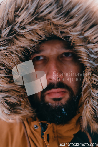 Image of Headshot photo of a man in a cold snowy area wearing a thick brown winter jacket and gloves. Life in cold regions of the country.