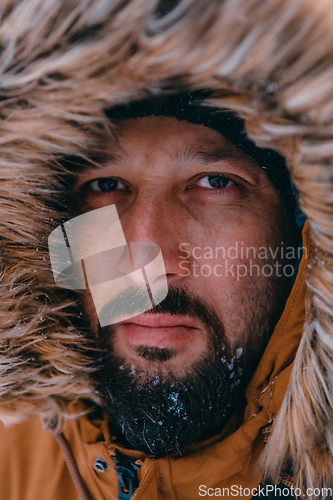 Image of Headshot photo of a man in a cold snowy area wearing a thick brown winter jacket and gloves. Life in cold regions of the country.