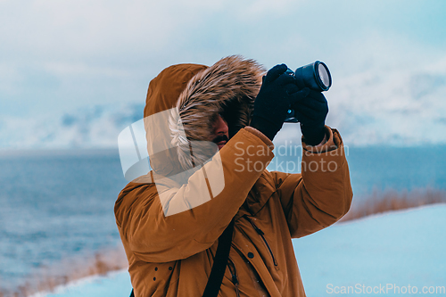 Image of A photographer in the cold Skavdinava regions tries to take a photo for journalism in a strong winter storm