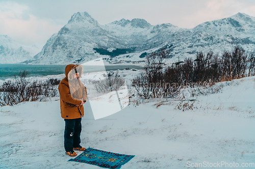 Image of A Muslim traveling through arctic cold regions while performing the Muslim prayer namaz during breaks