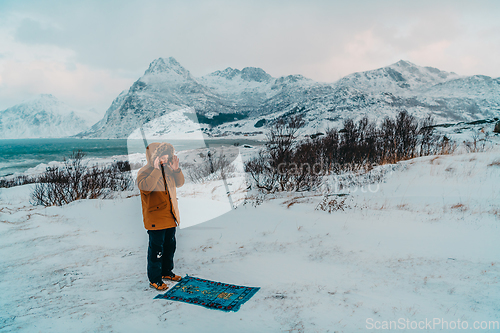 Image of A Muslim traveling through arctic cold regions while performing the Muslim prayer namaz during breaks